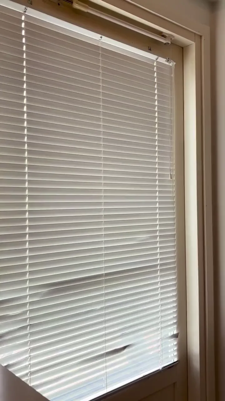 The old white Venetian blind before removal